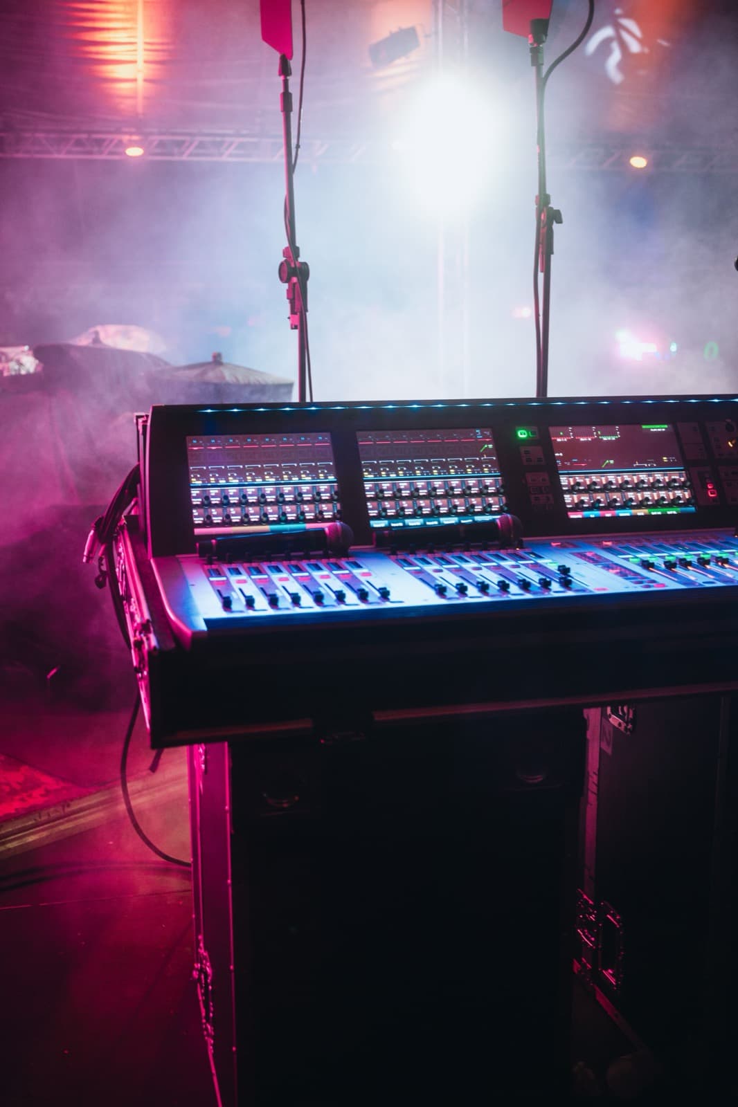 Digital audio mixing console on stage with colored lighting