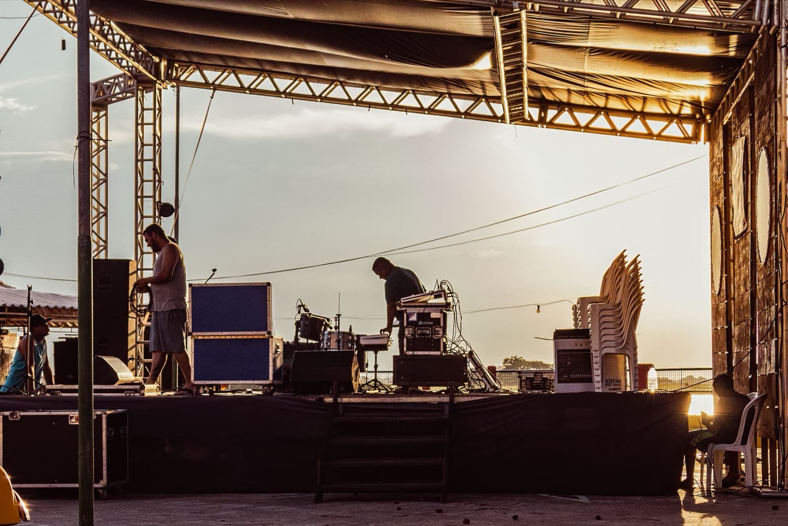 Crew setting up stage equipment with road cases and a mixer