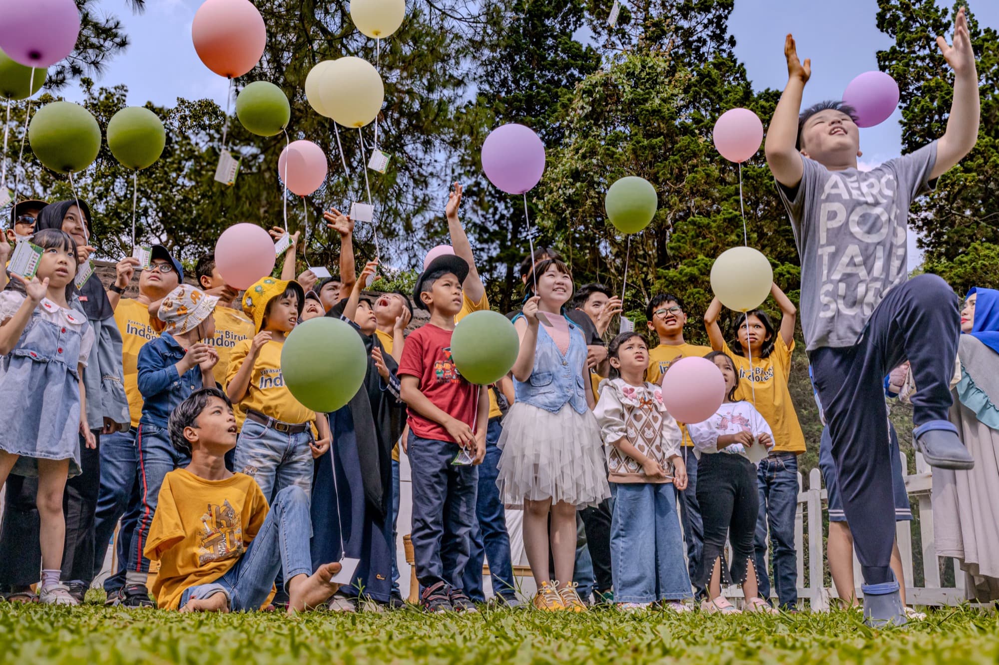 Children releasing balloons at an outdoor event