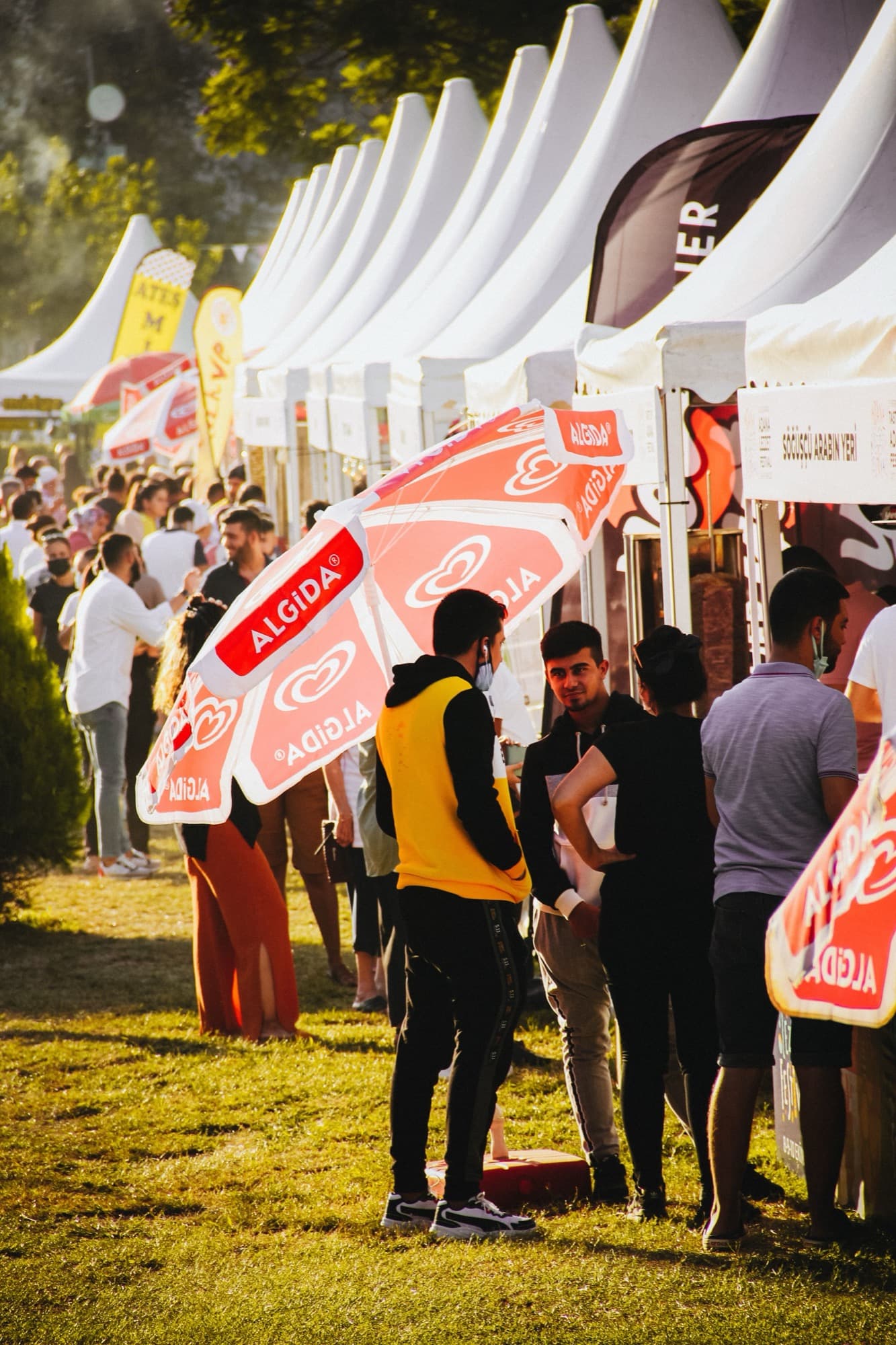 Row of branded tents and crowd at an outdoor festival